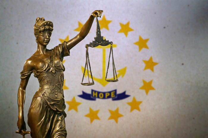 Lady Justice before the Rhode Island state flag